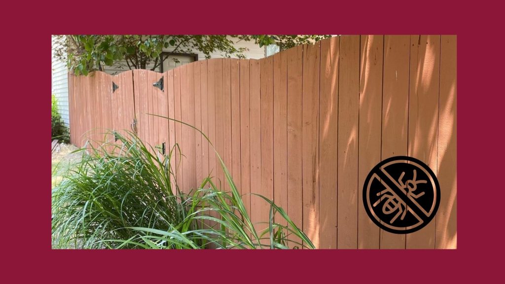 Technician sealing wooden fence to protect panels from moisture and rot